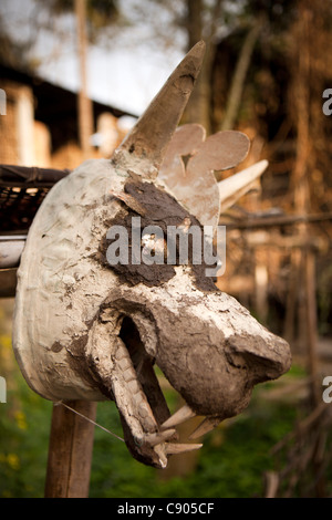 L'Inde, de l'Assam, de l'Île Majuli, artisanat, fabrication de masques, atelier, masque de loup avec face modelée en argile séchant sur piquet Banque D'Images