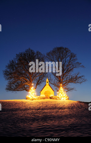 Chapelle illuminée avec deux arbres de Noël illuminés, le lac de Chiemsee, Chiemgau, Upper Bavaria, Bavaria, Germany, Europe Banque D'Images