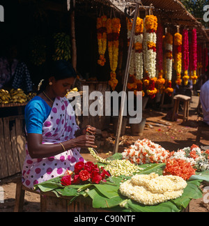 En dehors de temples en Inde il y a des étals de fleurs et de gens qui vendent des guirlandes de fleurs qui sont utilisés comme des offrandes religieuses. Banque D'Images