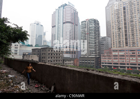 Bâtiments résidentiels à Chongqing femme marchant dans une ruelle jonchée de détritus et de déchets en République populaire de Chongqing Banque D'Images