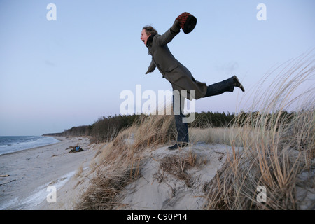 Femme en équilibre sur un seul aliment dans des dunes, mer Baltique spa Ahrenshoop, Mecklembourg-Poméranie occidentale, Allemagne Banque D'Images