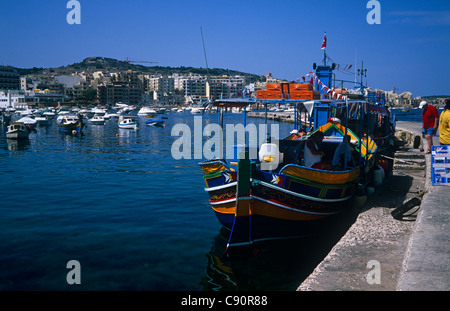 St Paul's Bay est une ville de villégiature sur la côte avec les luzzu bateaux de pêche amarrés dans le port. Banque D'Images