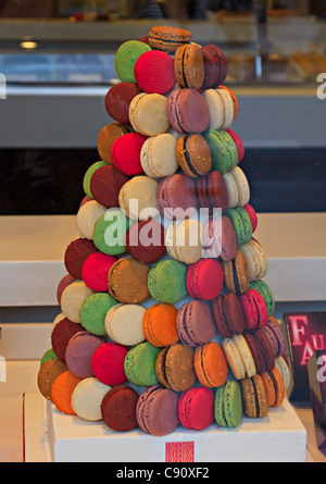 Affichage des macarons colorés dans la fenêtre d'une boutique à Paris. Macarons sucrés sont formés dans une tour. Banque D'Images