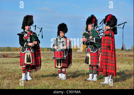 Cornemuse des Highlands écossais jouant Pipes and Drums dans les landes, Ecosse, Royaume-Uni Banque D'Images