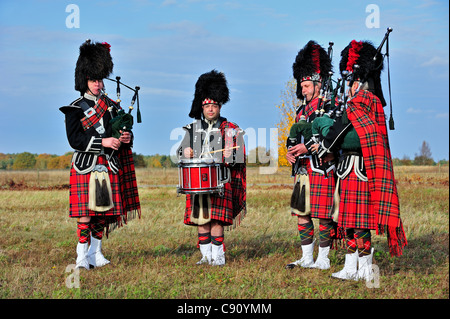 Cornemuse des Highlands écossais jouant Pipes and Drums dans la lande, Ecosse, Royaume-Uni Banque D'Images