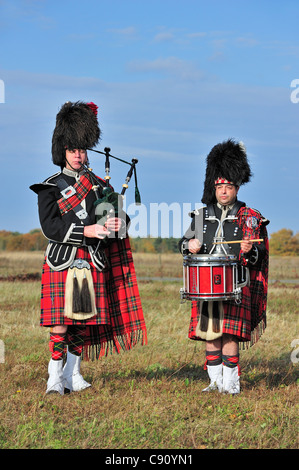 Cornemuse des Highlands écossais jouant Pipes and Drums dans la lande, Ecosse, Royaume-Uni Banque D'Images