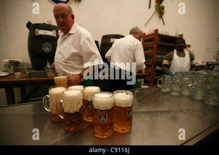 La bière d'un litre remplissage barmen masses dans la Hofbrau Festzelt à la fête de la bière de Munich, Allemagne. Banque D'Images