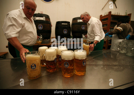 La bière d'un litre remplissage barmen masses dans la Hofbrau Festzelt à la fête de la bière de Munich, Allemagne. Banque D'Images