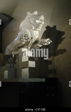 Statue en marbre de la République tchèque lion héraldique saute au-dessus de la double croix héraldique Slovaque Tchèque par Jan Štursa sculpteur moderniste affichés dans l'exposition permanente l'histoire du Château de Prague dans l'ancien Palais Royal (Stary kralovsky palace) à Prague, République tchèque. La statue a été conçu comme le haut de l'obélisque dédié aux victimes de la Première Guerre mondiale par l'architecte slovène Joze Plecnik. La statue n'était pas utilisé parce que l'obélisque a été cassé pendant le transport. Banque D'Images