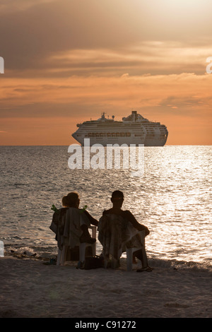 Les Pays-Bas, l'île de Bonaire, Antilles néerlandaises, Kralendijk, navire de croisière. Couple relaxing on beach. Le coucher du soleil. Banque D'Images