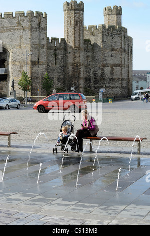 Femme et enfant dans une poussette place du château caernarfon gwynedd North Wales UK Banque D'Images