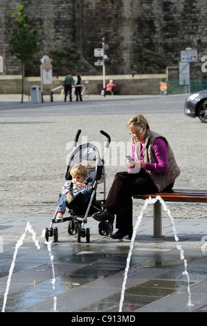 Femme et enfant dans une poussette place du château caernarfon gwynedd North Wales UK Banque D'Images