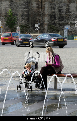 Femme et enfant dans une poussette place du château caernarfon gwynedd North Wales UK Banque D'Images