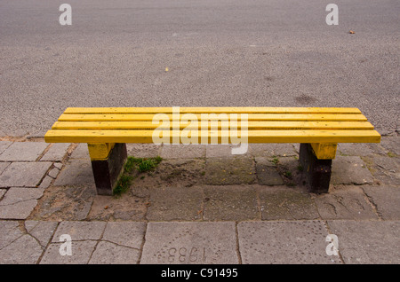 Banc jaune vide dans la rue sur le pavé Banque D'Images