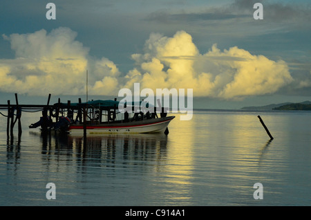 Bateau amarré à l'embarcadère de Kri Resort sur Raja Ampat islands matin orageux de Papouasie occidentale dans l'océan Pacifique, l'Indonésie. Banque D'Images
