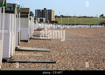 Une rangée de cabines de plage peint en blanc, à Hastings, East Sussex, Côte Sud, England, UK Banque D'Images