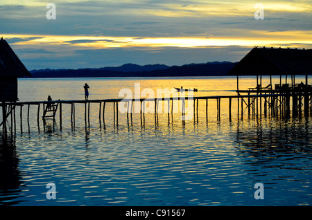 Kri Eco Resort en silhouette au coucher du soleil, Raja Ampat îles de Papouasie occidentale dans l'océan Pacifique, l'Indonésie. Banque D'Images