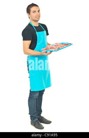 Toute la longueur de smiling butcher en tablier bleu holding viande isolé sur fond blanc Banque D'Images