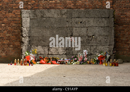 Mur de la mort à Auschwitz 1 camp de concentration, à côté de la case 11 avec tributs floraux et lampes colorées et des bougies. Auschwitz Banque D'Images