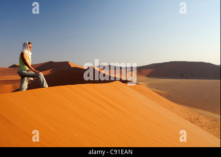 Femme debout sur la dune de sable rouge et bénéficiant dune vue à Sossusvlei Sossusvlei 45 Parc National Namib Naukluft Namib desert Nam Banque D'Images