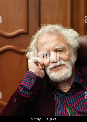 Smiling older man sitting in armchair Banque D'Images