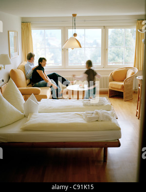 Mère, père et fille se détendre dans la chambre d'hôtel, Hotel, Hotel Restaurant, Hirschegg Kleinwalsertal, Styrie, Autriche Banque D'Images