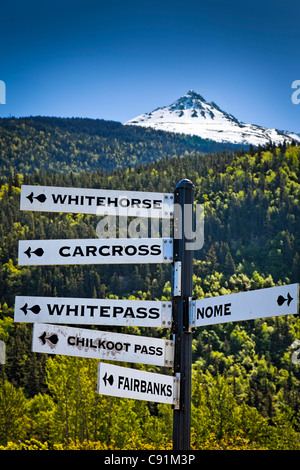 Près d'un p u milepost signe avec une vue panoramique d'une montagne enneigée en arrière-plan, Skagway, Alaska du Sud-Est, l'été Banque D'Images