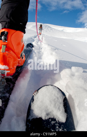 Low angle view of skieurs cordée de quitter le camp sur le glacier du triumvirat à escalader le mont Amaranta, montagnes Tordrillo, Alaska Banque D'Images