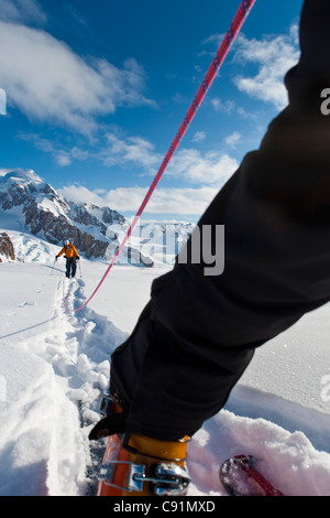 Low angle view of skieurs cordée de quitter le camp sur le glacier du triumvirat à escalader le mont Amaranta, montagnes Tordrillo, Alaska Banque D'Images