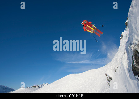 Le skieur alpin fait un saut extrême d'un ledge en skiant à Resort Alyeska, Southcentral Alaska, Winter Banque D'Images