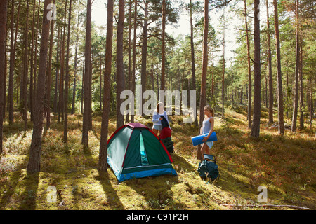 Les femmes la mise en place de camping en forêt Banque D'Images