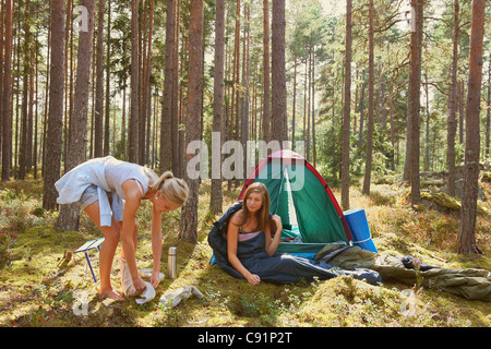 Les femmes la mise en place de camping en forêt Banque D'Images