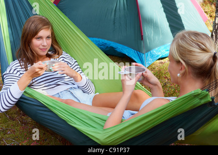 Women relaxing in hammock at campsite Banque D'Images