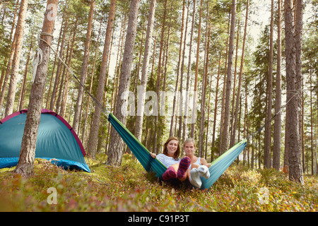 Women relaxing in hammock at campsite Banque D'Images