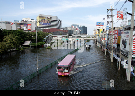 Un bus conduit par le déluge d'en face d'un centre commercial le 8 novembre 2011 à ladprao district, Bangkok , Thaïlande. Plus de sept grands parcs industriels de Bangkok et des milliers d'usines ont été fermées .La Thaïlande connaît les pires inondations depuis plus de 50 ans . Banque D'Images