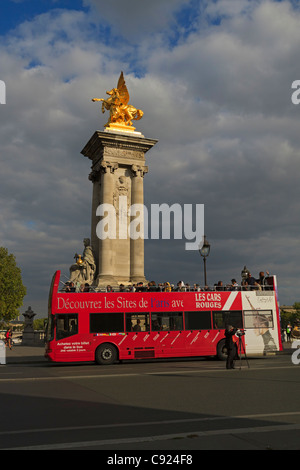 Un rouge double decker bus touristique passe l'emblématique pont Alexandre III, Paris, France. Banque D'Images