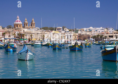 Le port de Marsaxlokk luzzu maltais traditionnel avec la location de bateaux de pêche peints dans les couleurs traditionnelles avec le Banque D'Images