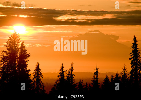 Un coucher de soleil sur le volcan Redoubt silhouettes Cook Inlet comme vu à partir de la péninsule de Kenai dans centre Sud de l'Alaska, l'été Banque D'Images