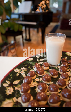 Libre d'un bac noir et or de cherry-remplie de biscuits, trempés à la main dans le chocolat pour Noël avec un verre de lait Banque D'Images