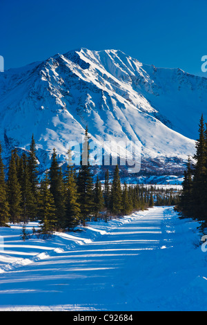 La neige a couvert route menant vers les montagnes au large col, Southcentral Alaska, Winter Banque D'Images