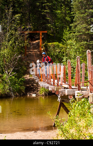Un père et son fils, la randonnée à travers un pont suspendu qui traverse Byers Creek sur le sentier du lac Byers dans Denali State Park, Alaska Banque D'Images