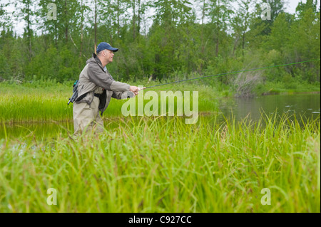 L'homme pêche à la mouche pour des saumons de Roi dans une rivière de l'arrière-pays, Southcentral Alaska, l'été Banque D'Images