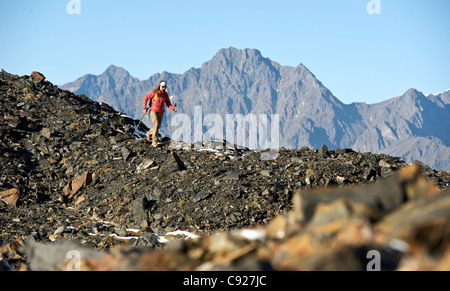 Femme randonnée sur le sentier du Col-de-Corbeau le long de la crête rocheuse, montagnes Chugach, Southcentral Alaska, automne Banque D'Images