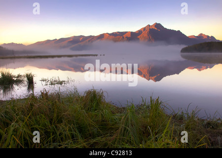 Lever du soleil sur le pic de Pioneer avec petite, Misty Lake au premier plan, Mat-Su Valley, Southcentral Alaska, automne Banque D'Images