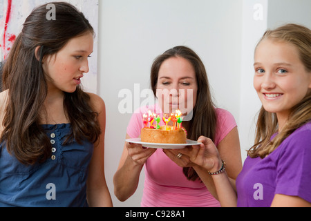 Mère blowing out birthday candles Banque D'Images