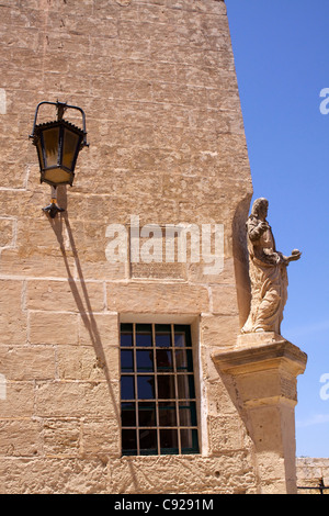 Statue de grès érodées de St.Peter sur un coin d'une rue de Città Vecchia de Mdina ou la vieille ville avec une inscription datant Banque D'Images
