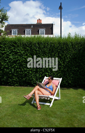 Femme lisant et bains de soleil Banque D'Images