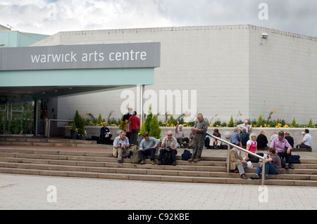 Un groupe de gens assis sur les marches à l'entrée de l'Université de Warwick Arts Centre Banque D'Images