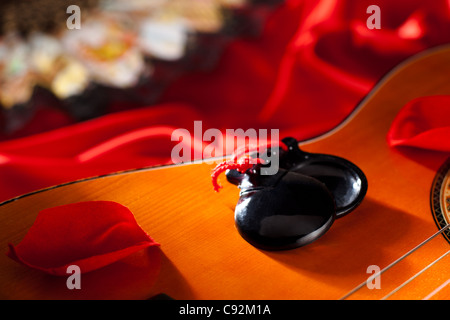 Les castagnettes avec des pétales de rose sur la guitare classique Banque D'Images