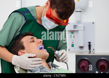 Dentiste à l'aide de rayons UV sur les dents des patients Banque D'Images